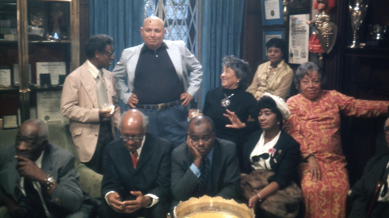 two men standing with a group of people
